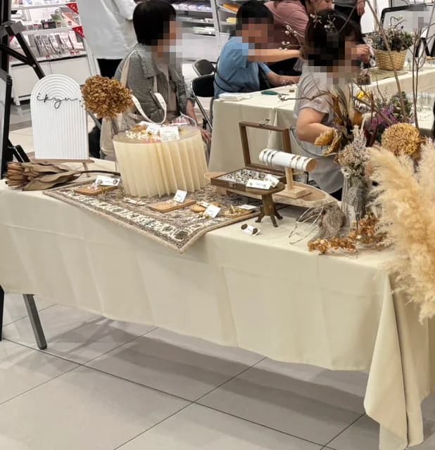 テーブルを囲み、かごの花材からフラワーボトルをつくる参加者のみなさん