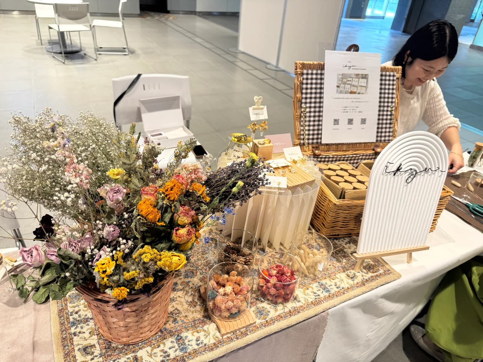チカホ北三条広場のikyuブース。かごいっぱいのドライフラワーと花材の小瓶、アクセサリーの展示台